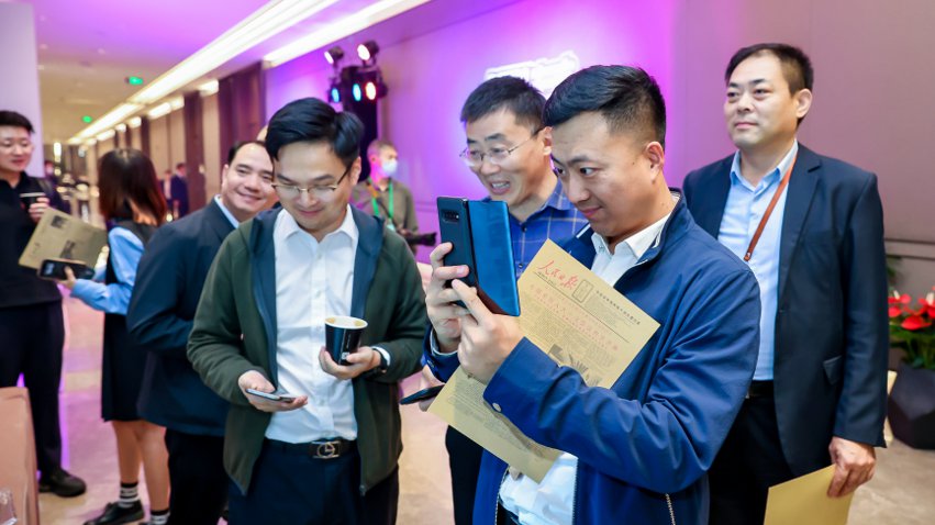 人民網(wǎng)研發(fā)推出的《人民日報(bào)》生日報(bào)吸引嘉賓體驗(yàn)。主辦方供圖